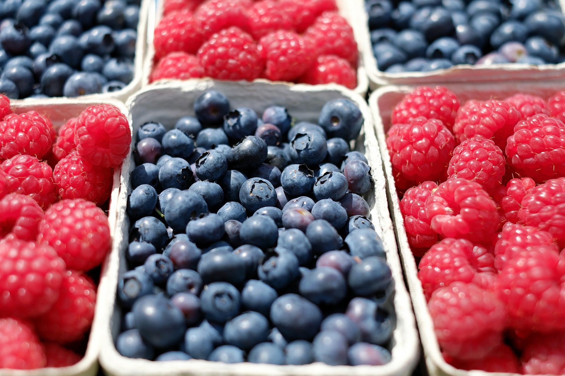 Packungen mit Himbeeren und Blaubeeren.