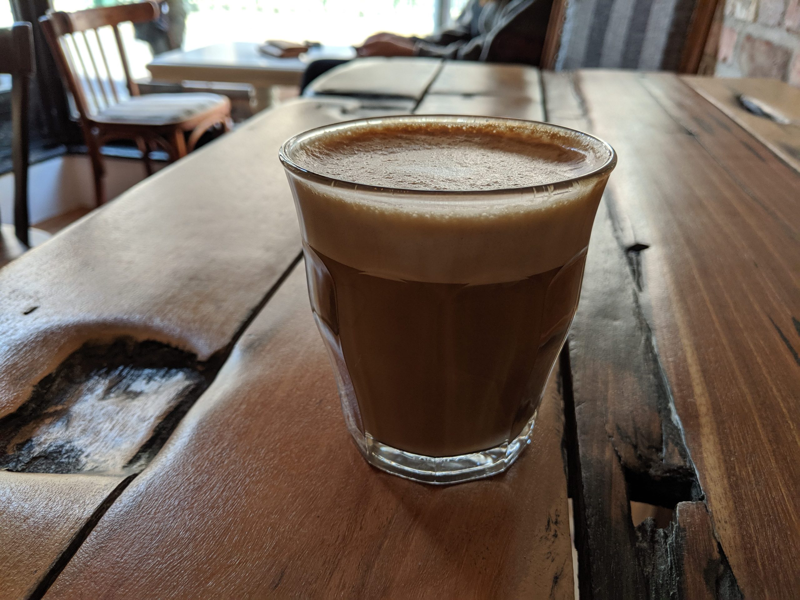 Ein Kaffee auf einem Holztisch.
