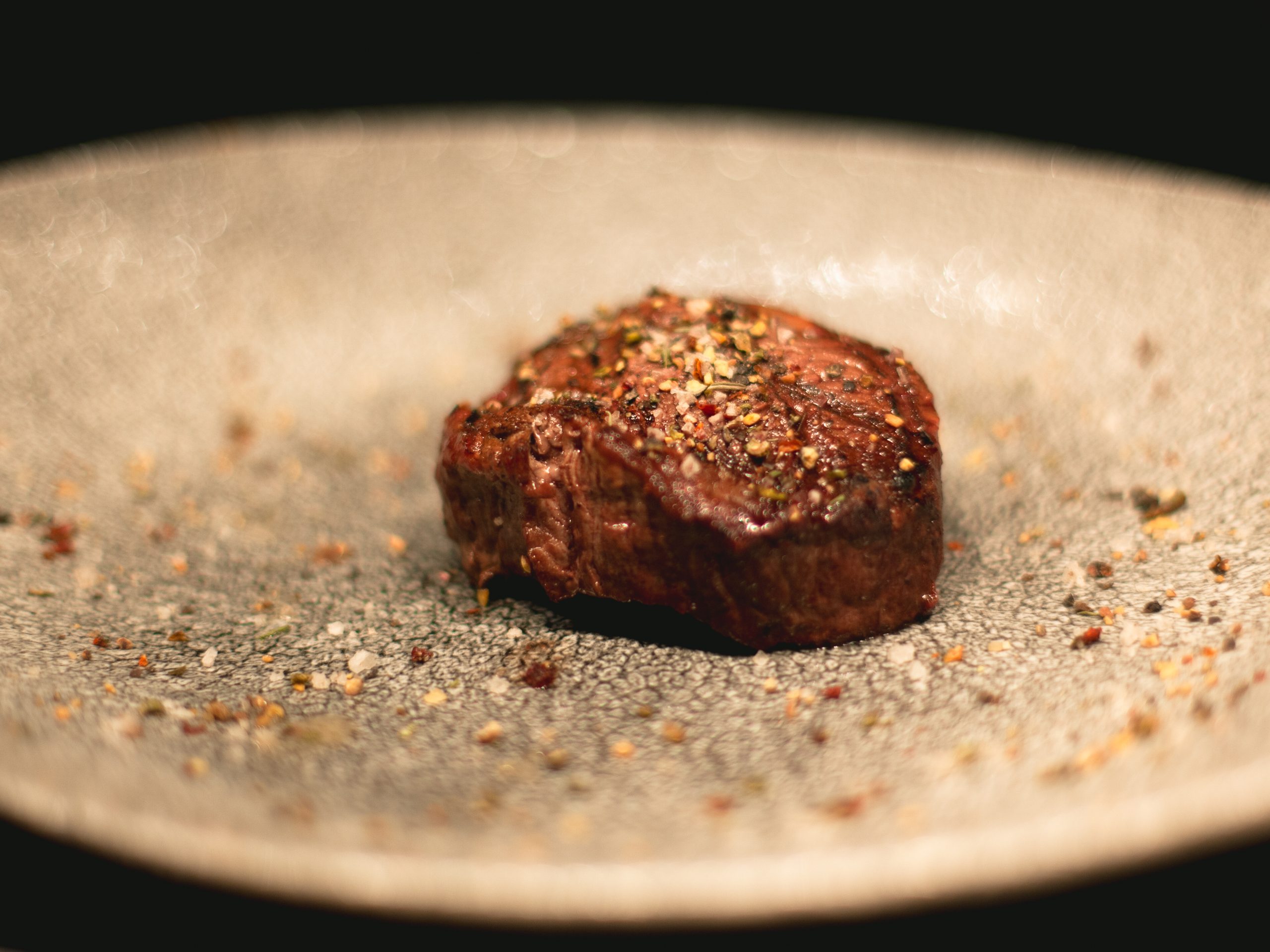 Ein Stück Steak mit Gewürzen auf einem Teller